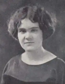 A young white woman with cropped, dark, wavy hair