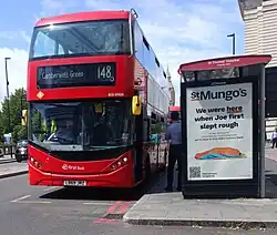 A London bus route 148 service calling at a bus shelter in London, United Kingdom