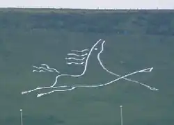 A stylised figure of a galloping white horse. Folkestone White Horse on Cheriton Hill, Folkestone