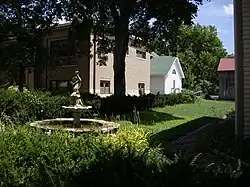 Fountain next to W.H. Morgan House (immediate right), W.H. Morgan Barn (back right with red roof), Carnegie Library (left with brown brick), Museum (back middle with green roof). Looking north-east in 2010.