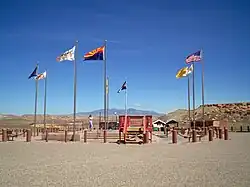 Flags surrounding the Four Corners Monument. In clockwise order starting from the frontmost flag, the state flag of Arizona, flag of the Navajo Nation, pre-2011 flag of Utah, Navajo nation (second instance)Ute Mountain Ute Tribe Reservation, Colorado, New Mexico, Navajo Nation (third instance), and the flag of the United States.