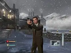 A man in a suit holding a gun. It is snowing, and a factory is on the background. On the bottom corners icons indicating ammo and health of the player can be seen.