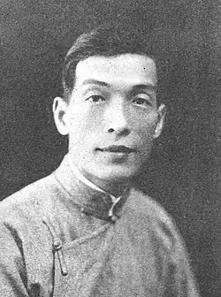 A black-and-white headshot of a man in a high-collared shirt