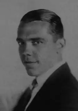 Black and white portrait photo of Rockwell wearing a suit