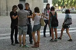 Image 55Teenagers in Italy wearing graphic tees, plaid shirts, cutoff shorts, and studded accessories popular early in the decade, 2010. (from 2010s in fashion)