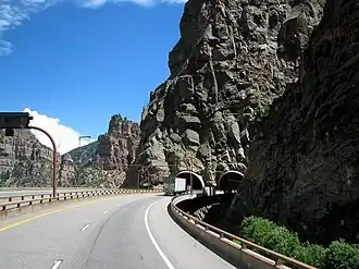 A pair of bridges leading to a pair of tunnels at the canyon wall