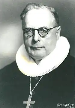 Portrait in black and white of Hans Fuglsang-Damgaard with spectacles and clerical clothing