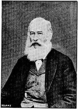 portrait photo of a man with a full beard in his 60s or 70s