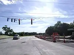 Looking west at intersection of IL-22 (Half Day Rd.) and US-45/IL-21 (Milwaukee Ave.) Taken in 2010 during intersection construction when eastbound side has been reconstructed with concrete and westbound side has been dug up to the ground. Traffic has been reduced to one lane in each direction.