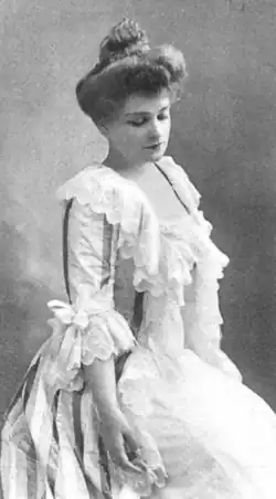 A young white woman wearing an historical costume gown with ruffles