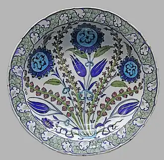 Turkish İznik pottery with rock and wave" scrolls round the rim, c.1550, stonepaste with underglaze decoration, British Museum