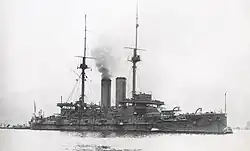 Large warship with smoke rising from the smokestack