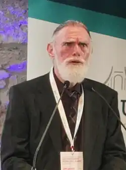 Kaplan speaking at a podium