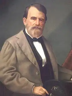 Painting shows a bearded man wearing civilian dress consisting of a grayish coat with a black vest and a white shirt.