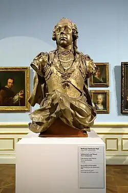 Bronze bust of a man displayed in a gallery.