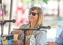 Kazek autographs a book at an outdoor festival