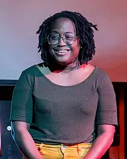 Kenice Mobley, an African American woman with locs wearing glasses, smiling.