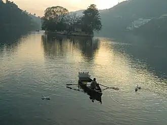 A Bhimtal lake dweller with his boat in Nainital district, Uttarakhand, India
