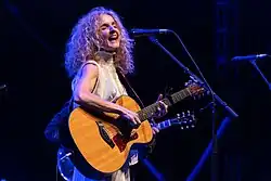 Griffin playing an acoustic guitar and singing