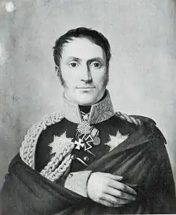 Black and white print of a man staring very intently right at the viewer. He wears a dark military coat with an Iron Cross and other awards.