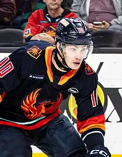 Hockey player wearing a white and orange Coachella Valley Firebirds jersey