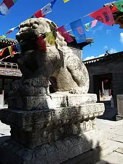 A Chinese guardian lion is placed in front of the Tianwang-dian.