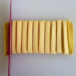 Sheets of pasta are folded and cut into slices.