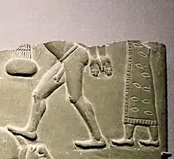 Man in patterned and fringed dress, holding a naked prisoner, in the Battlefield Palette, circa 3100 BC.[23][24][22]