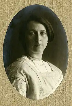 Portrait photograph of Hardegger, a woman with a short bob haircut, wearing a white dress
