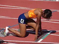 Ta Lou in a starting position in the blocks before a race