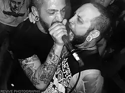 An unmasked Matthew Tybor (left) performing live in Peoria, IL in 2013.