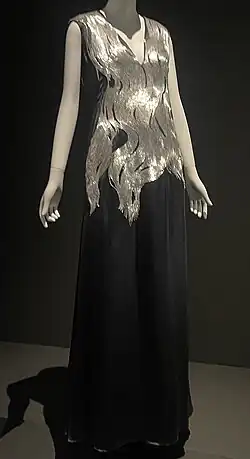 Black sleeveless floor-length dress, with silver beading resembling hair from shoulders to waist