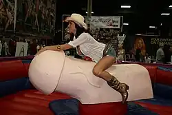 A woman riding a phallic mechanical bull at EXXXOTICA New York 2009