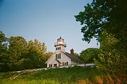 The lighthouse from the beach in August 2023