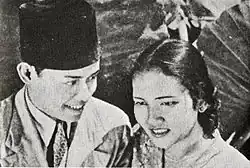 A man and woman standing close together; both are in their mid-20s.
