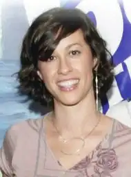 Woman smiling in front of a multi-coloured background