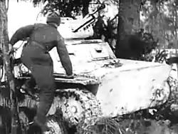 20:15 – A crewman jumps aboard his snow-camouflaged tank