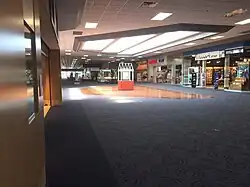 The interior of Mounds Mall, showing a carpeted concourse and several store fronts