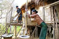 Mru women working in a village in Bangladesh. One of them is wearing traditional clothing.