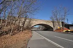 A concrete arch bridge over a four-lane roadway