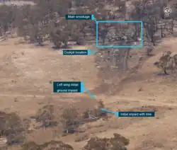 Wide aerial image showing the accident site and the trial of debris.