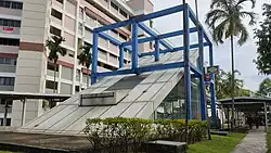 Photograph of Serangoon station entrance, encased in a blue cubic structure
