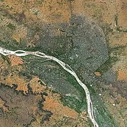 A river flowing southeast, curving inward on each side. Development on both sides of the river, mostly the northeast side.