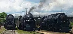 Three steam locomotives on display with one in the middle being operational