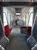 Tram interior with a step-free floor. Some sections have two seats either side of the aisle, some have longitudinal seating against the wall on one side.