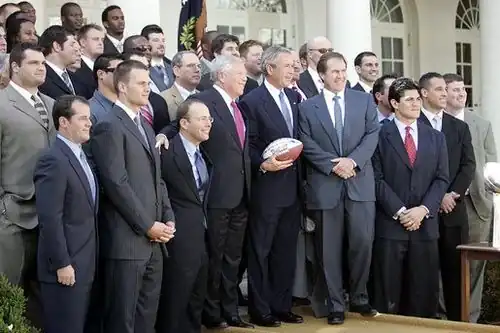 A large group of men standing together, including George Bush and Robert Kraft in the middle.