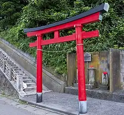 The typical pentagonal profile of a torii's kasagi. Note the black nemaki.
