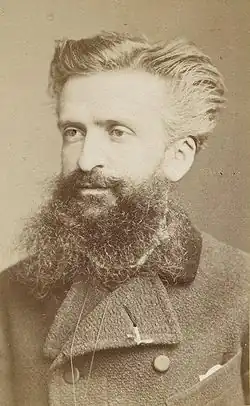 Portrait of a man in his thirties with swept back hair and a large beard