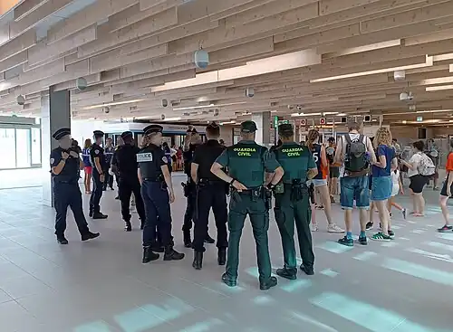 Two groups of police forces providing security inside of a train station