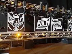 A stage rig with the Polymarchs logo in the foreground